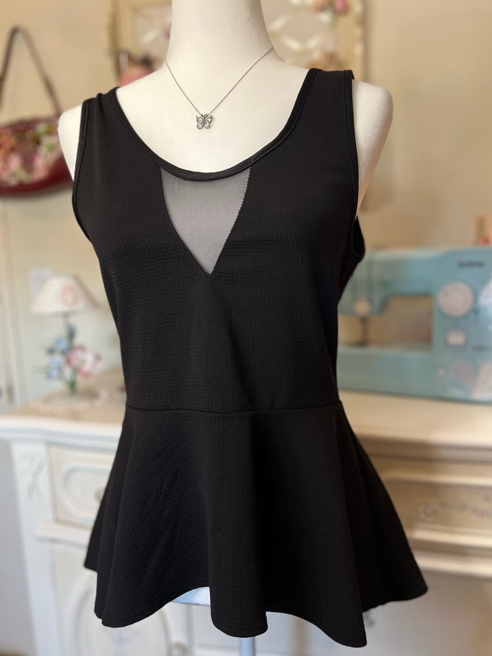 Sleek Black Sleeveless Peplum Tank with Mesh V-Inset